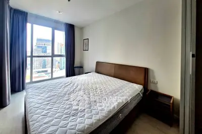 Spacious bedroom with large window and city view in modern apartment