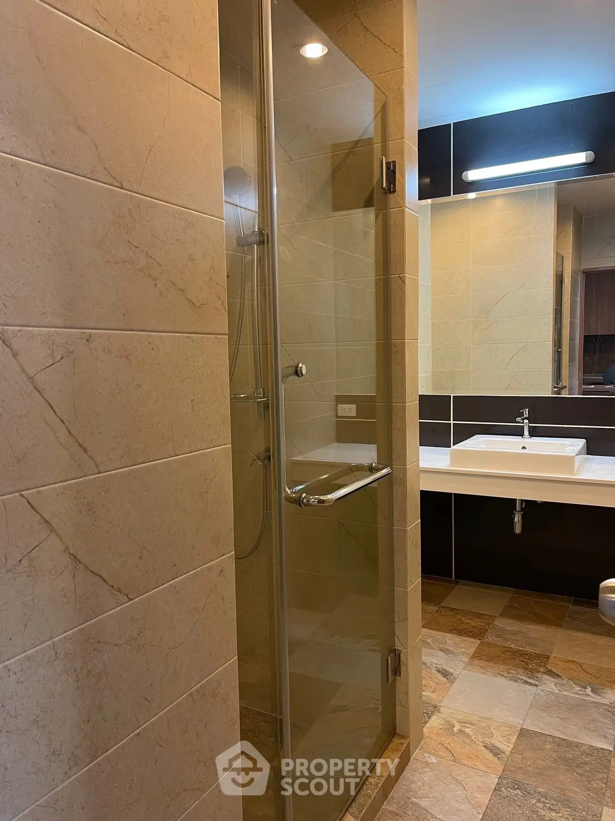 Modern bathroom with glass shower and elegant sink design.