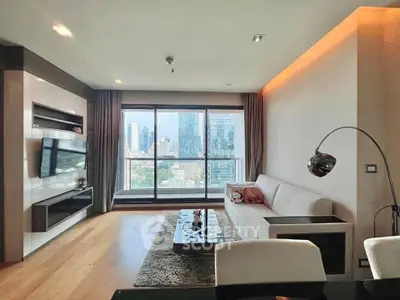 Modern living room with city view, sleek furniture, and large windows in a high-rise apartment.