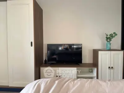 Modern bedroom with sleek wardrobe and TV unit, perfect for stylish living.