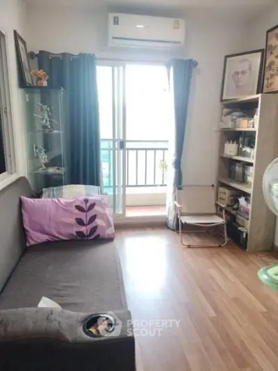 Cozy living room with balcony access, featuring modern decor and natural light.