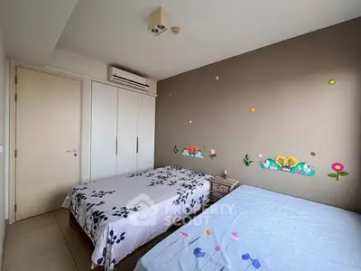 Charming bedroom with dual beds and playful wall decor, perfect for a cozy family home.