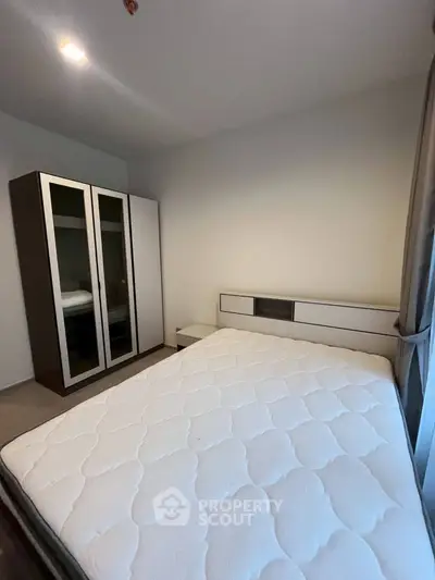 Cozy bedroom with modern wardrobe and comfortable mattress, perfect for relaxation.