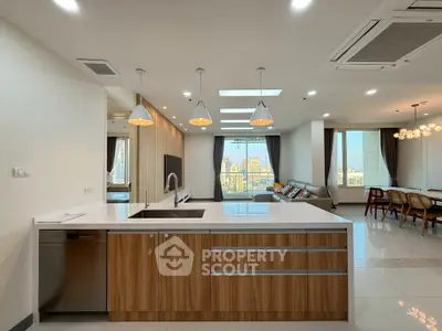 Modern open kitchen with sleek design and city view, featuring a spacious living area and elegant lighting.