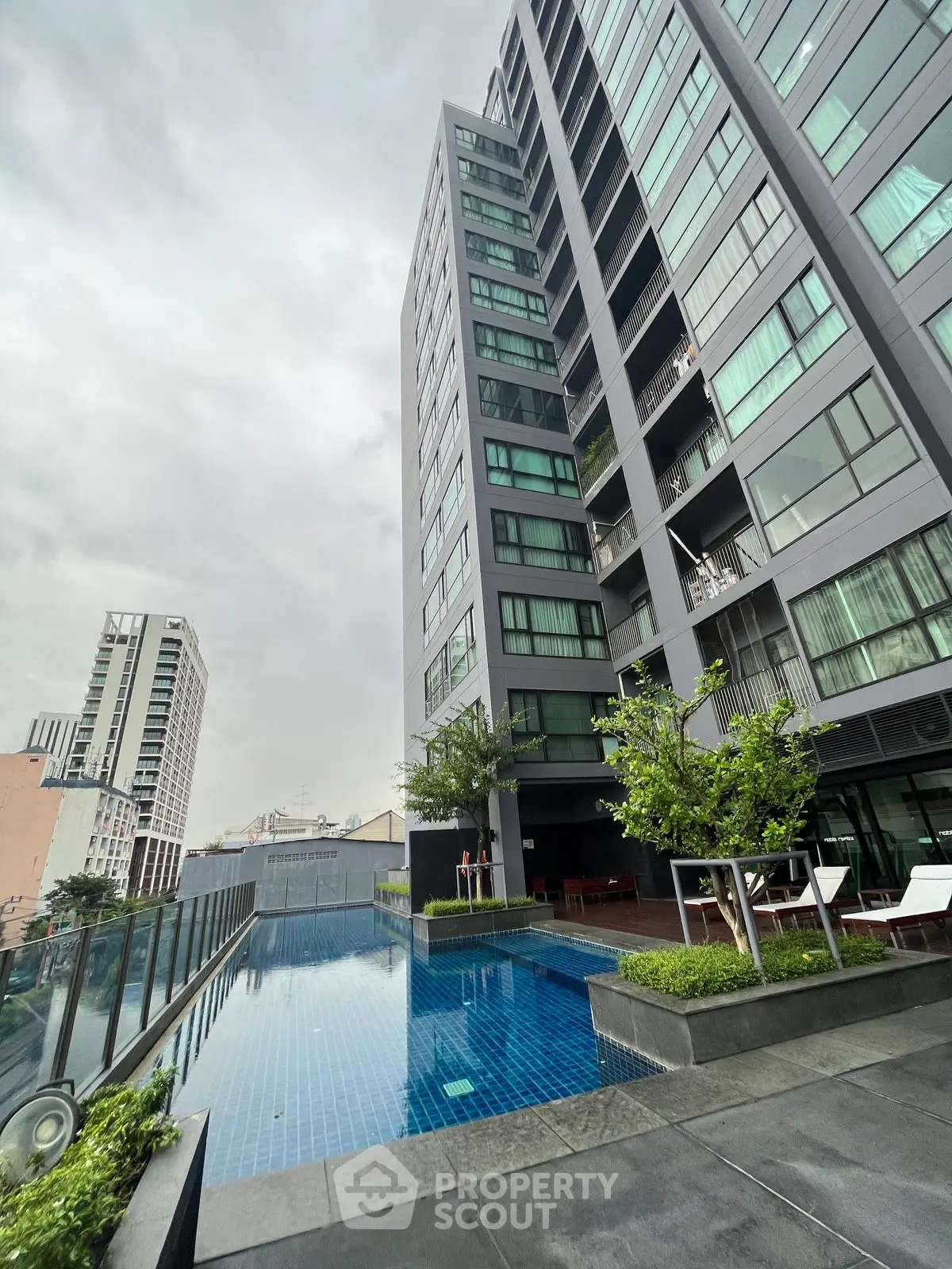 Modern high-rise building with rooftop pool and city view, perfect for urban living.