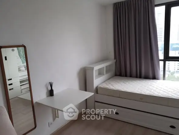 Cozy bedroom with single bed and window view in modern apartment