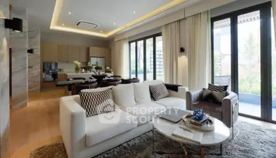 Luxurious open-plan living room with modern decor and large windows.