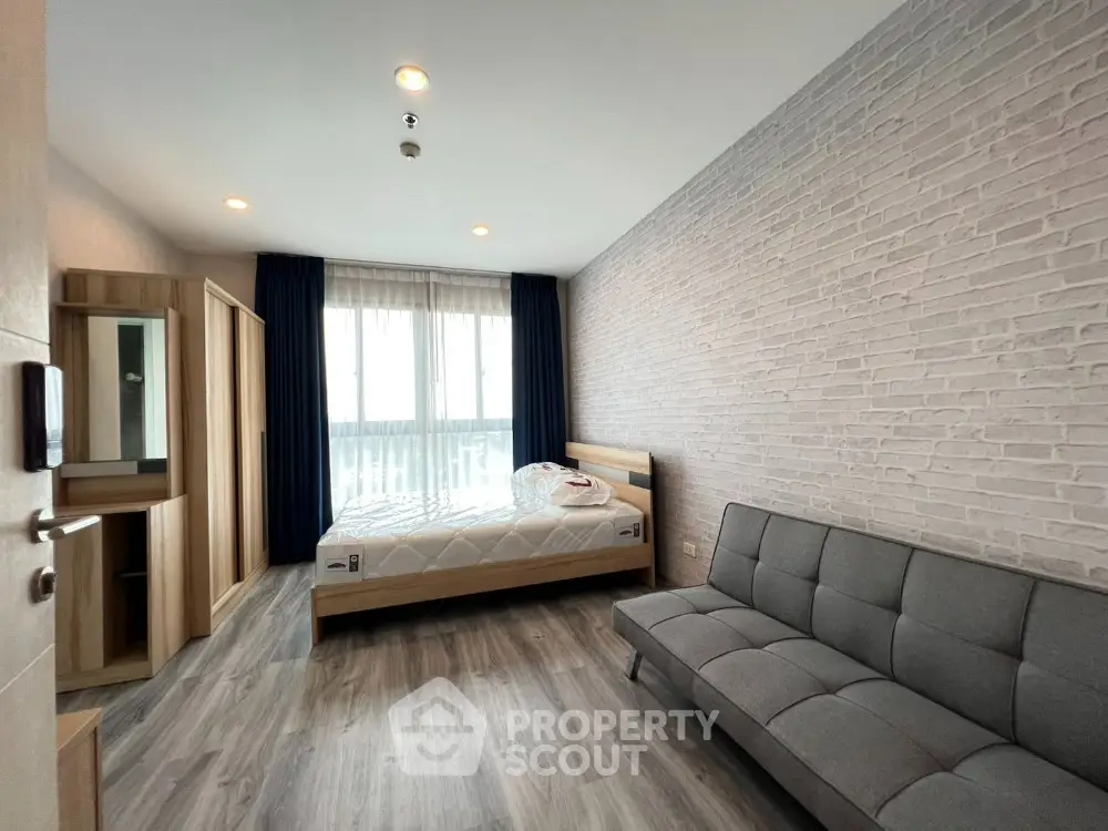 Modern bedroom with stylish decor, featuring a cozy bed and sleek sofa, perfect for urban living.