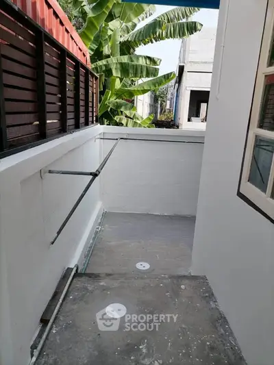 Charming outdoor space with privacy fence and lush greenery, perfect for relaxation or small gatherings.