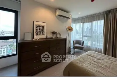 Modern bedroom with city view, featuring stylish decor and ample natural light.