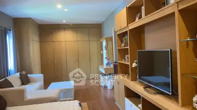 Spacious living room with modern wooden cabinetry and cozy seating area.