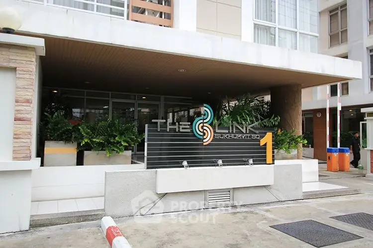 Modern building entrance with sleek design and lush greenery at The Link Sukhumvit.