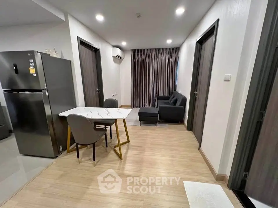 Modern apartment interior with open layout, featuring sleek kitchen and cozy living area.