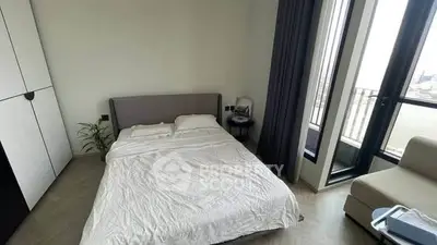 Modern bedroom with large windows and balcony access, featuring a cozy bed and minimalist decor.
