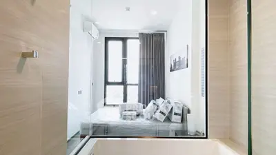 Modern bedroom with glass partition and stylish decor in a high-rise apartment.