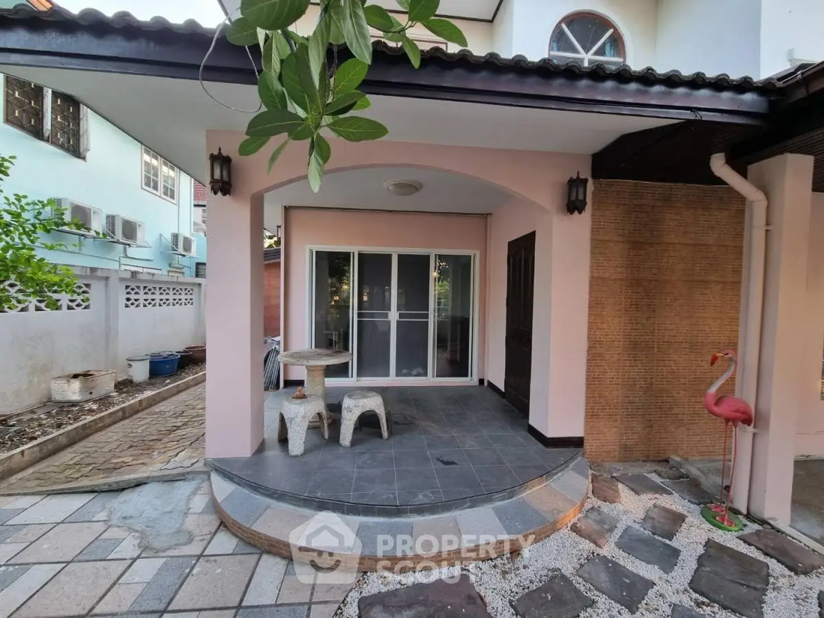 Charming exterior patio with stylish tile flooring and cozy seating area in a serene residential setting.