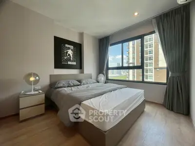 Modern bedroom with large window and city view, featuring stylish decor and cozy ambiance.