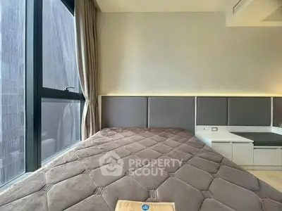 Modern bedroom with large window and stylish headboard in urban apartment