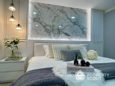 Luxurious bedroom with marble accent wall and designer decor