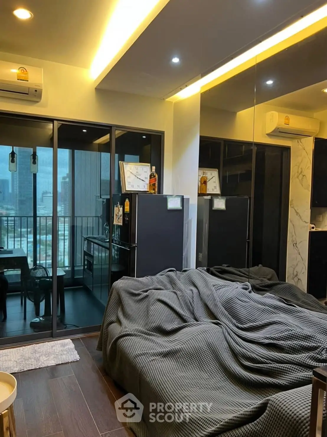 Modern studio apartment with mirrored wall and balcony view