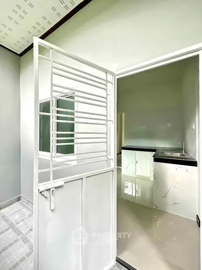 Modern kitchen with sleek white cabinetry and marble countertops in a bright, minimalist space.