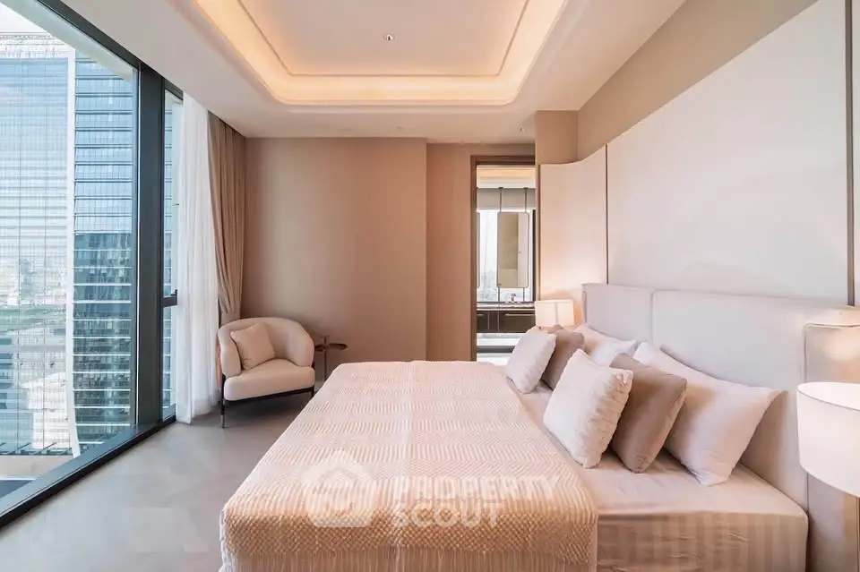 Luxurious bedroom with floor-to-ceiling windows and modern decor in a high-rise apartment.