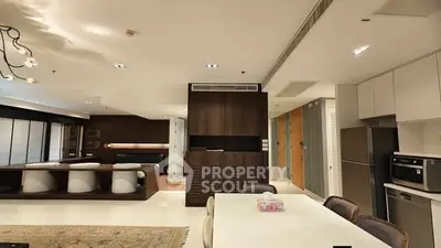 Luxurious open-plan living and dining area with modern kitchen appliances and elegant decor.