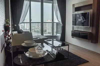 Modern living room with large windows and city view, featuring sleek furniture and wall-mounted TV.