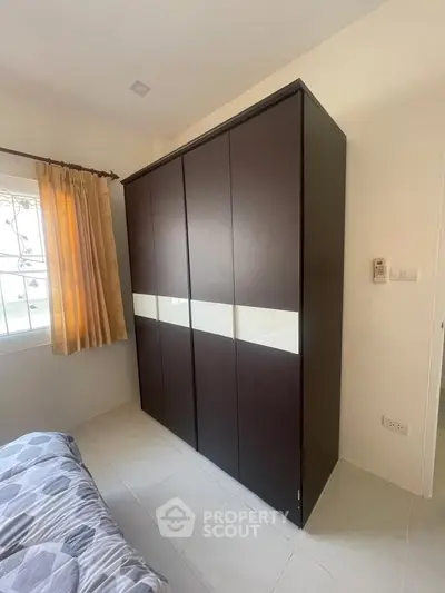 Spacious bedroom with modern wardrobe and natural light