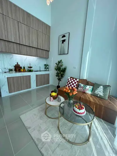 Modern living room with stylish kitchen and cozy seating area, featuring elegant decor and natural light.