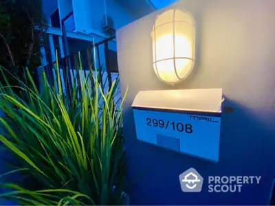 Modern exterior mailbox with ambient lighting and lush greenery