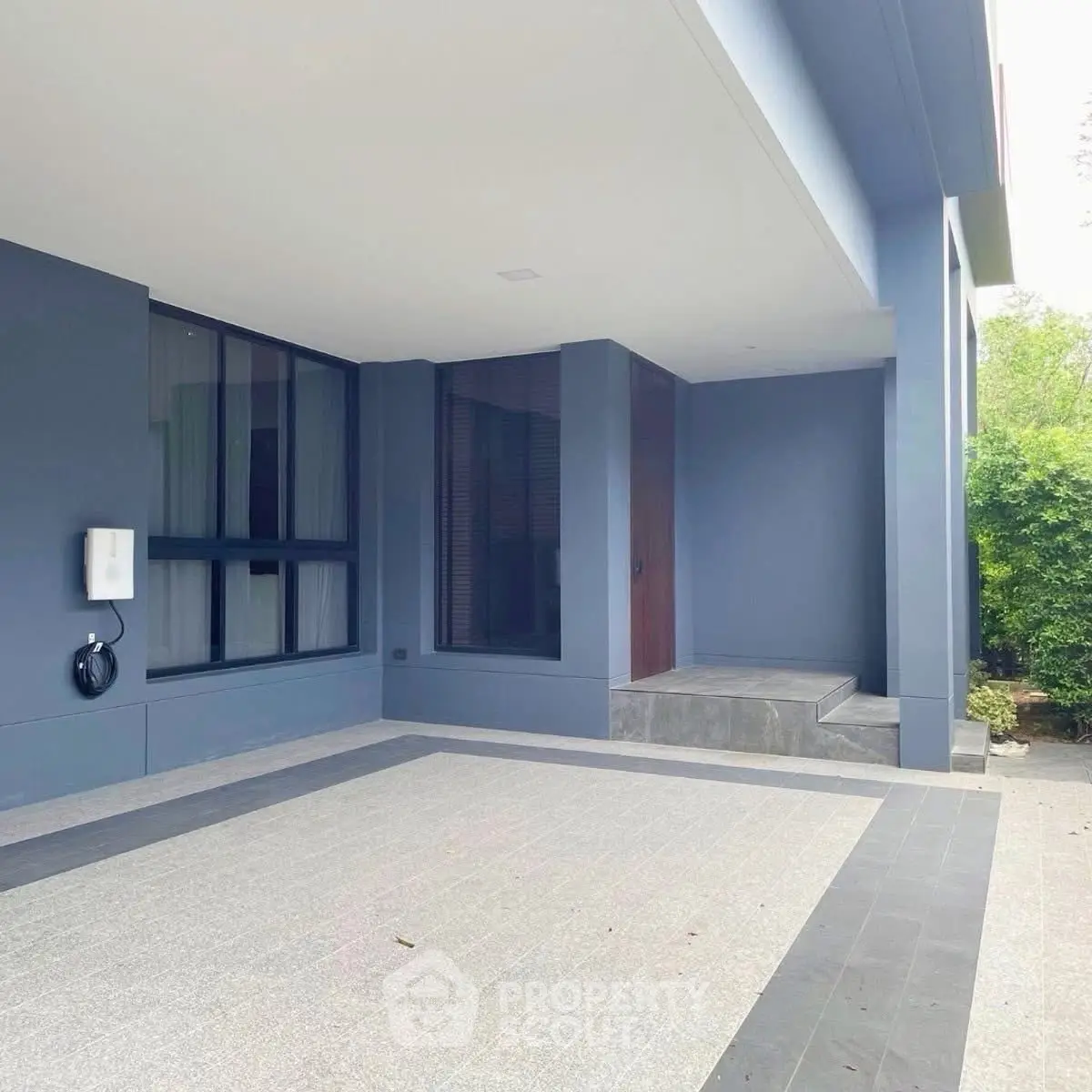 Modern residential building exterior with sleek design and spacious entrance area.