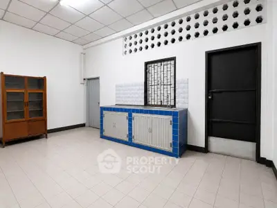 Spacious interior room with tiled floor and built-in storage, ideal for versatile use.