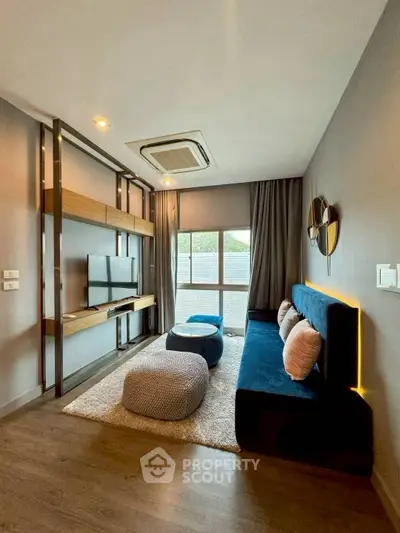 Modern living room with stylish decor and natural light, featuring a cozy sofa and entertainment setup.