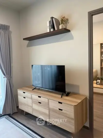 Modern living room with sleek TV stand and wall shelf, perfect for stylish urban living.