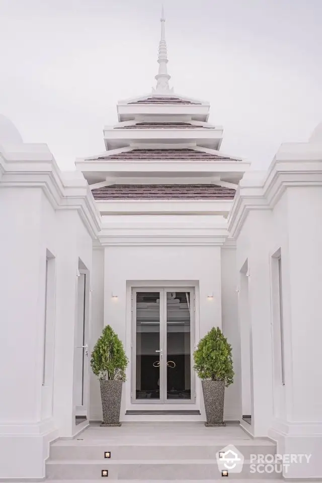 Elegant architectural entrance with symmetrical design and decorative plants