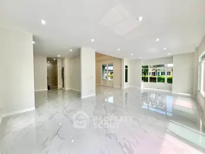 Spacious modern living room with glossy marble floors and large windows offering abundant natural light.