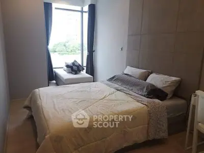 Cozy bedroom with large window and modern decor in a stylish apartment.
