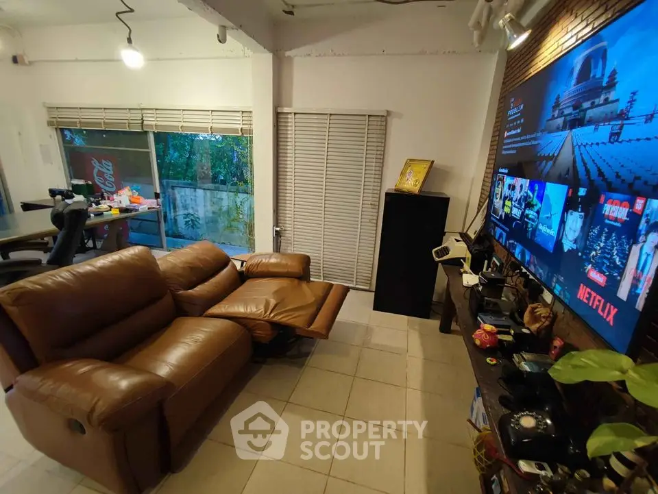Cozy living room with leather recliners and large TV, perfect for entertainment.