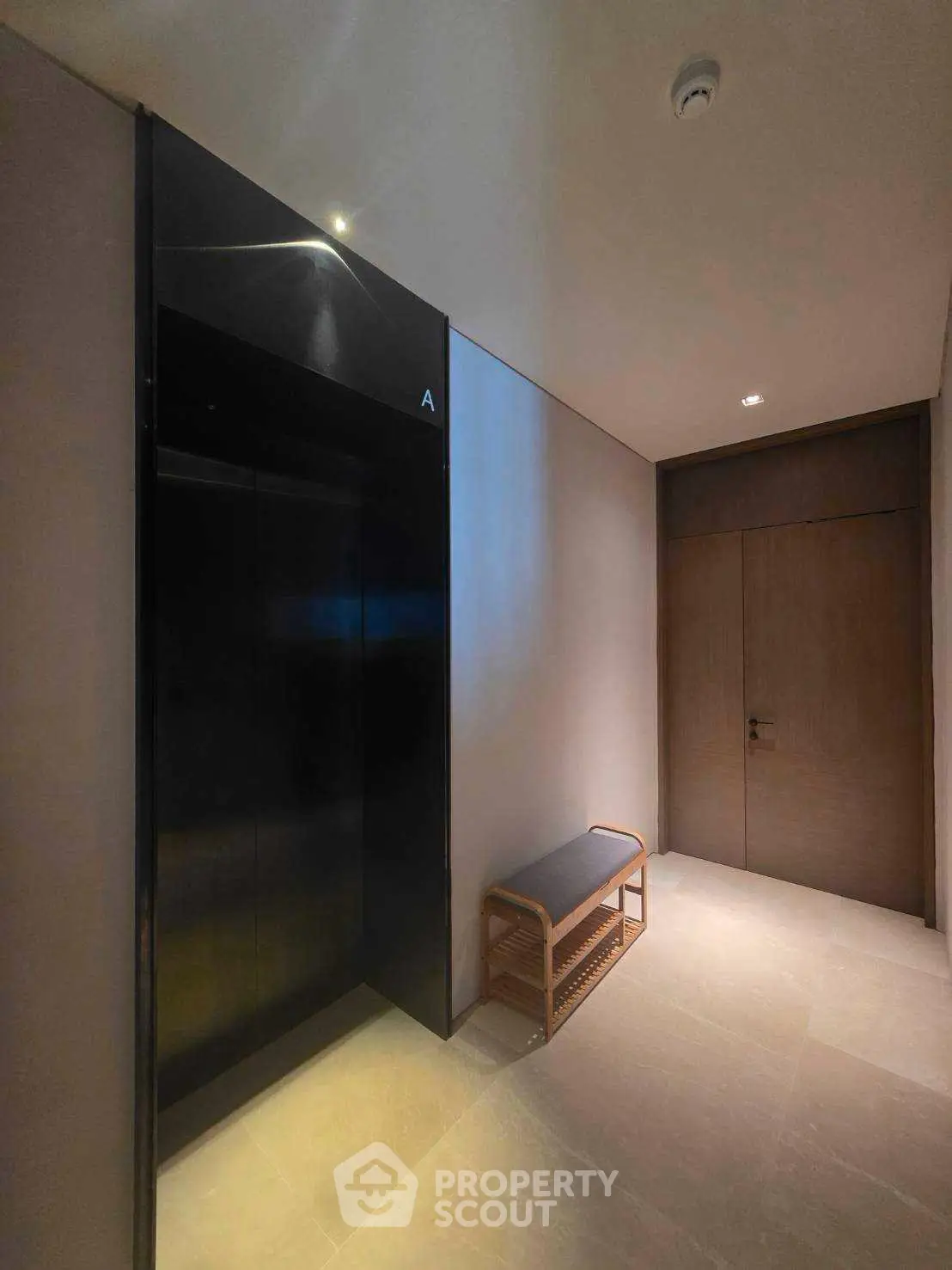 Modern building corridor with sleek elevator and stylish bench seating.
