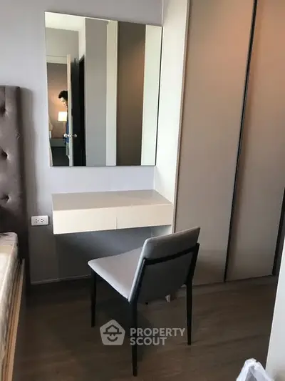 Modern bedroom with sleek vanity and chair, perfect for urban living.