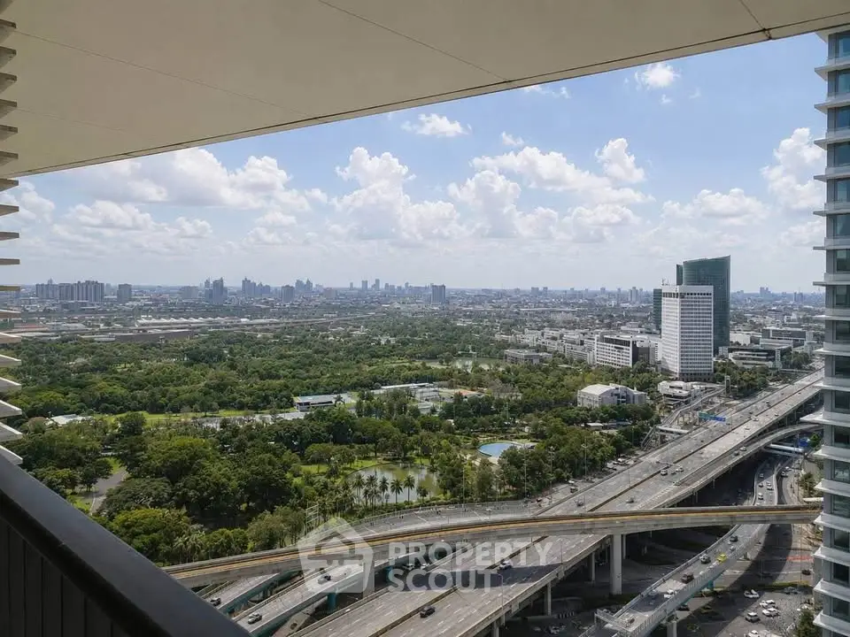 Stunning cityscape view from a high-rise balcony overlooking lush greenery and urban skyline.