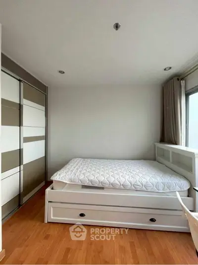 Modern bedroom with sleek design and ample storage space.