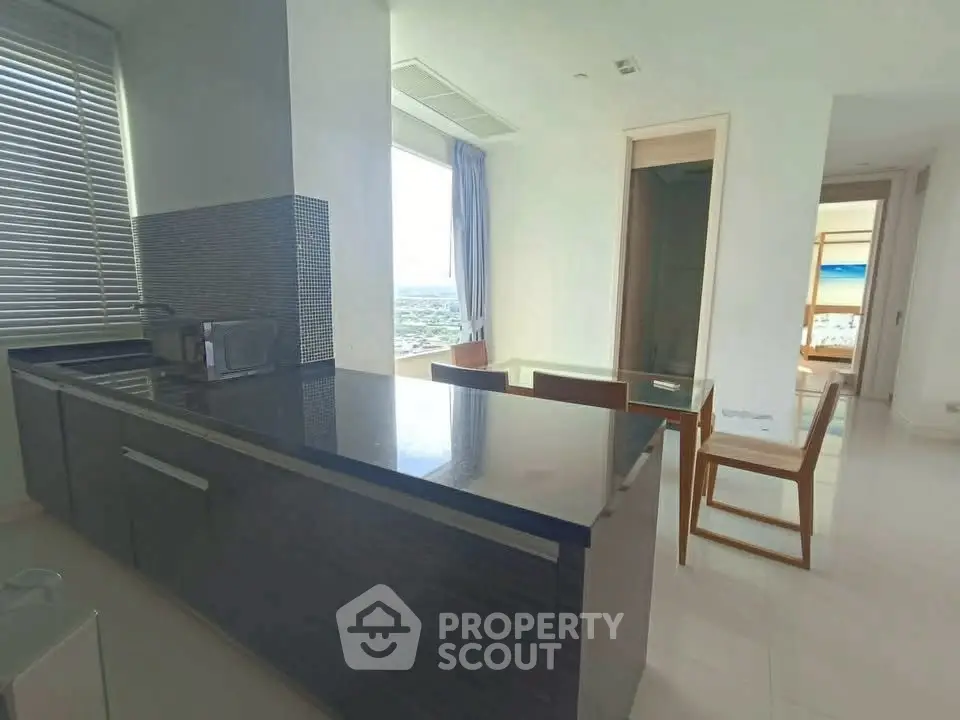 Modern kitchen with sleek countertops and dining area with city view