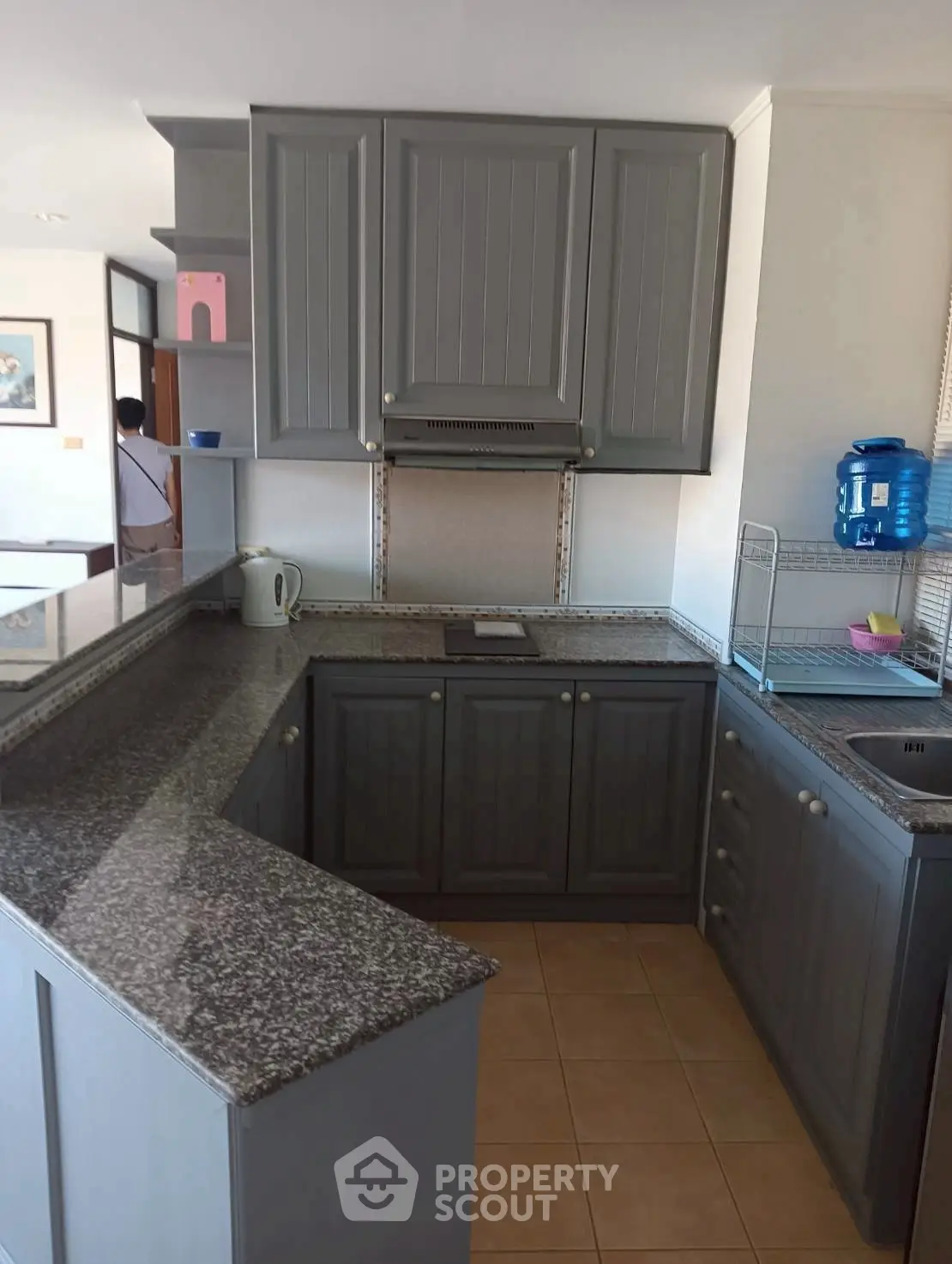 Modern kitchen with granite countertops and sleek cabinetry in a stylish apartment.