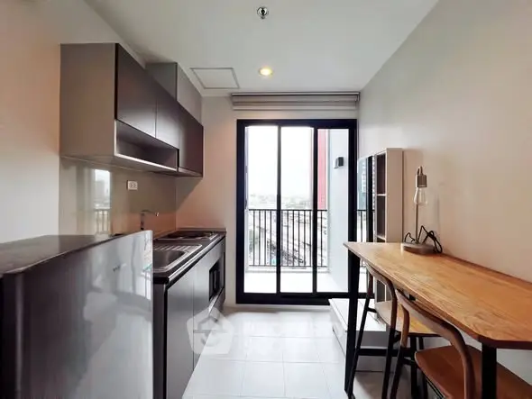 Modern kitchen with sleek cabinets and balcony view, perfect for urban living.