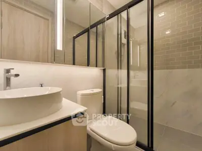 Modern bathroom with glass shower and sleek fixtures in contemporary apartment.