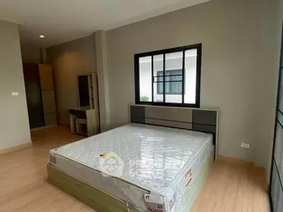 Spacious bedroom with modern design and large window for natural light.