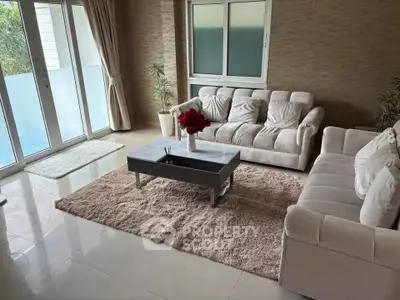 Elegant living room with plush sofas, modern coffee table, and large windows offering natural light.