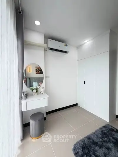 Modern bedroom with sleek white wardrobe and stylish vanity area
